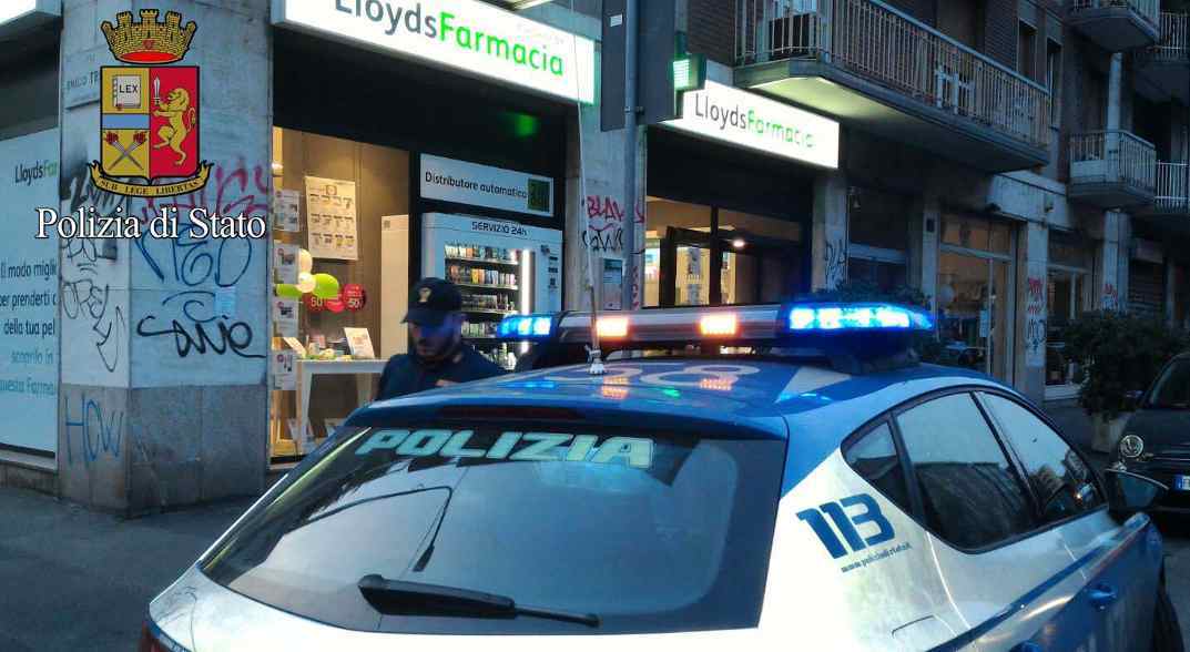 Foto di un'auto della polizia davanti ad una farmacia